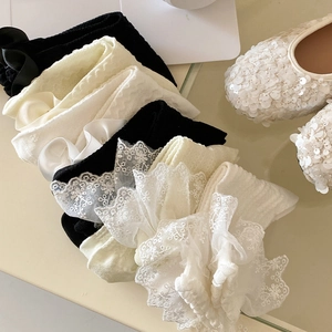 Detail von Lolita-Socken mit Spitzenborte, Seidenschleifen und Rippenstruktur in drei Farben