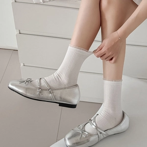 Silver Mary Jane shoes with double straps and bow paired with white cable knit socks