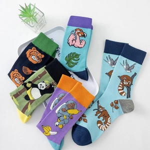 Close-up of five colorful knitted mid-calf socks with various cartoon animal patterns