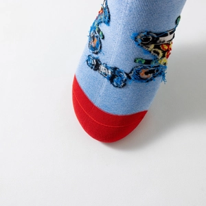 Detail of light blue knit cotton sock with red toe and frayed deconstructed embroidery