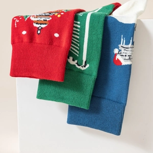 Dettaglio di calze natalizie in cotone jacquard rosso verde e blu con motivi festivi