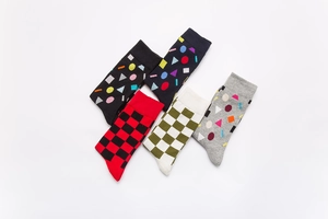 Flat lay of five mid-calf cotton socks with colorful geometric patterns and plaid designs