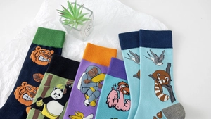 Detailed view of colorful cotton socks with vibrant cartoon animal patterns and ribbed cuffs