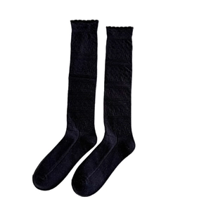 Grey ballet style knee-high socks featuring argyle patterns and ruffled trim on white background