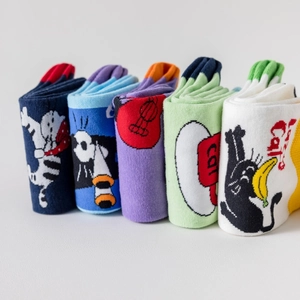 Detail of five pairs of colorful cotton socks with artistic cartoon cat patterns