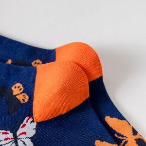 Vue macro détaillée des chaussettes en coton bleu marine avec talon orange et motif papillon