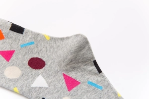 Macro shot of grey cotton socks featuring colorful geometric patterns and knit texture