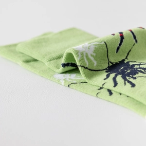 Vue détaillée des chaussettes en coton vert avec un motif jacquard d'insecte unique
