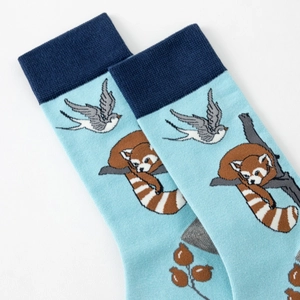Detail of light blue cotton crew socks featuring red panda and swallow animal patterns
