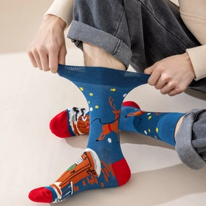 Dettaglio del polsino elastico a coste di calze natalizie blu con motivi di renne e baite