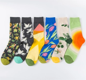 Flat lay of six pairs of creative art mid-calf socks with diverse floral and geometric patterns