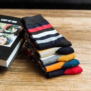 Stylish men's mid-calf cotton socks with colorful stripes on a rustic wood surface