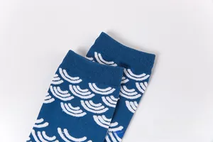 Vue détaillée de chaussettes bleu marine à motifs vagues blanches et bords côtelés