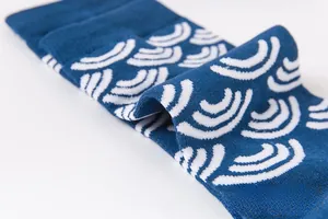 Gros plan de chaussettes en coton bleu foncé avec motif de vagues en jacquard blanc