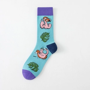 Detail view of blue cotton socks with tropical flamingo and monstera leaf patterns