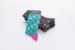 Pile of cotton crew socks featuring colorful hot air balloon and palm tree patterns