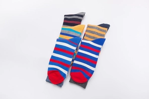 Detail of colorful striped cotton crew socks with vibrant patterns and red toe accents