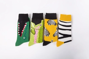 Close-up of four colorful cotton socks featuring cartoon animal patterns and striped designs