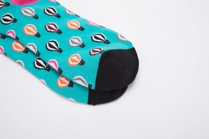 Detail of blue cotton socks featuring colorful hot air balloon patterns and black toes