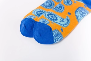 Macro view of blue paisley pattern and fine knit texture on orange cotton socks