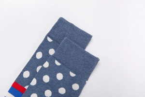 Close-up of blue polka dot cotton socks with ribbed cuffs and colorful striped edges