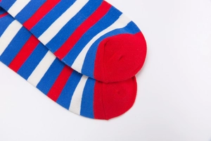 Close-up of red, white, and blue striped cotton socks with reinforced red toe detail