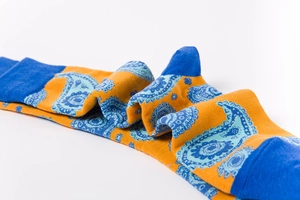 Detail of knit socks showing orange and navy paisley patterns and texture