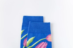 Detail of blue crew socks featuring pink tulip floral patterns and elastic ribbed cuffs