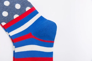 Detail of colorful knitted socks featuring blue stripes and white polka dots pattern