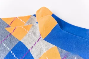 Detail shot of argyle knit socks featuring royal blue, orange and grey diamond patterns