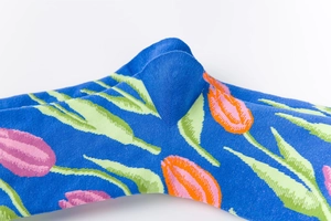 Close-up of royal blue socks with pink tulip floral patterns and reinforced heel knitting