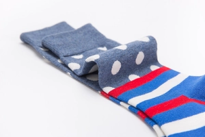 Detail of blue cotton socks with white polka dots and red-white-blue striped patterns