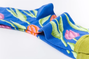 Detailed close-up of blue cotton socks with pink tulip pattern and yellow toe accent