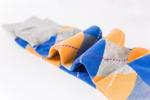 Close-up of argyle knit socks in navy blue, yellow, and grey with classic diamond pattern