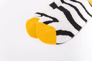 Macro shot of knitted zebra pattern socks with vibrant yellow contrast toe detail