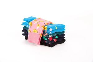 Close-up of colorful mid-calf socks with banana, flamingo, and strawberry print patterns