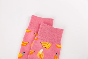 Detailed close-up of pink cotton socks featuring banana prints and ribbed cuffs