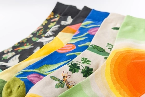 Close-up of five colorful socks with bird, mountain, and flower prints on white background