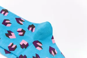 Detailed close-up of sky blue cotton socks with 3D pink and purple geometric patterns