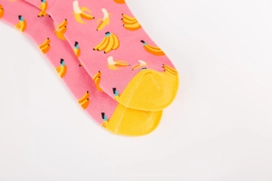 Pink crew sock featuring yellow banana patterns with contrasting toe and heel details