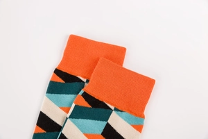 Détail macro de chaussettes en tricot à motifs géométriques avec poignets orange
