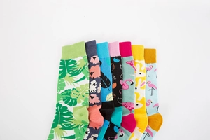 Macro detail of colorful crew socks with tropical leaf and animal knit patterns