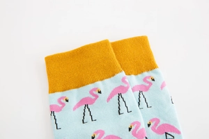 Detail of flamingo pattern and yellow ribbed cuff on blue cotton crew socks