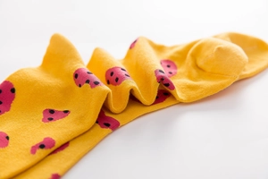 Macro shot of yellow cotton crew socks with pink polka dots and detailed knit texture
