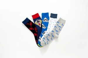 Close-up of five pairs of cotton socks featuring knitted whale and shark animal patterns