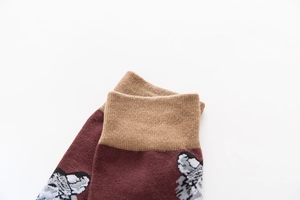 Detail of burgundy cotton crew sock with ribbed cream cuff and cute dog pattern embroidery