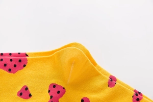 Detailed macro view of yellow cotton sock featuring pink strawberry polka dots and heel seam