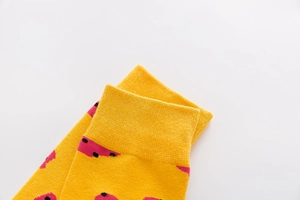 Detail of yellow cotton mid-calf socks with pink polka dots and ribbed knit texture