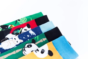 Close-up of assorted crew socks with panda, toucan and tropical leaf patterns