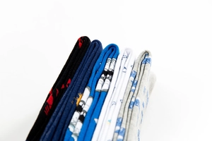 Close-up of five pairs of colorful cotton crew socks stacked to show fabric texture